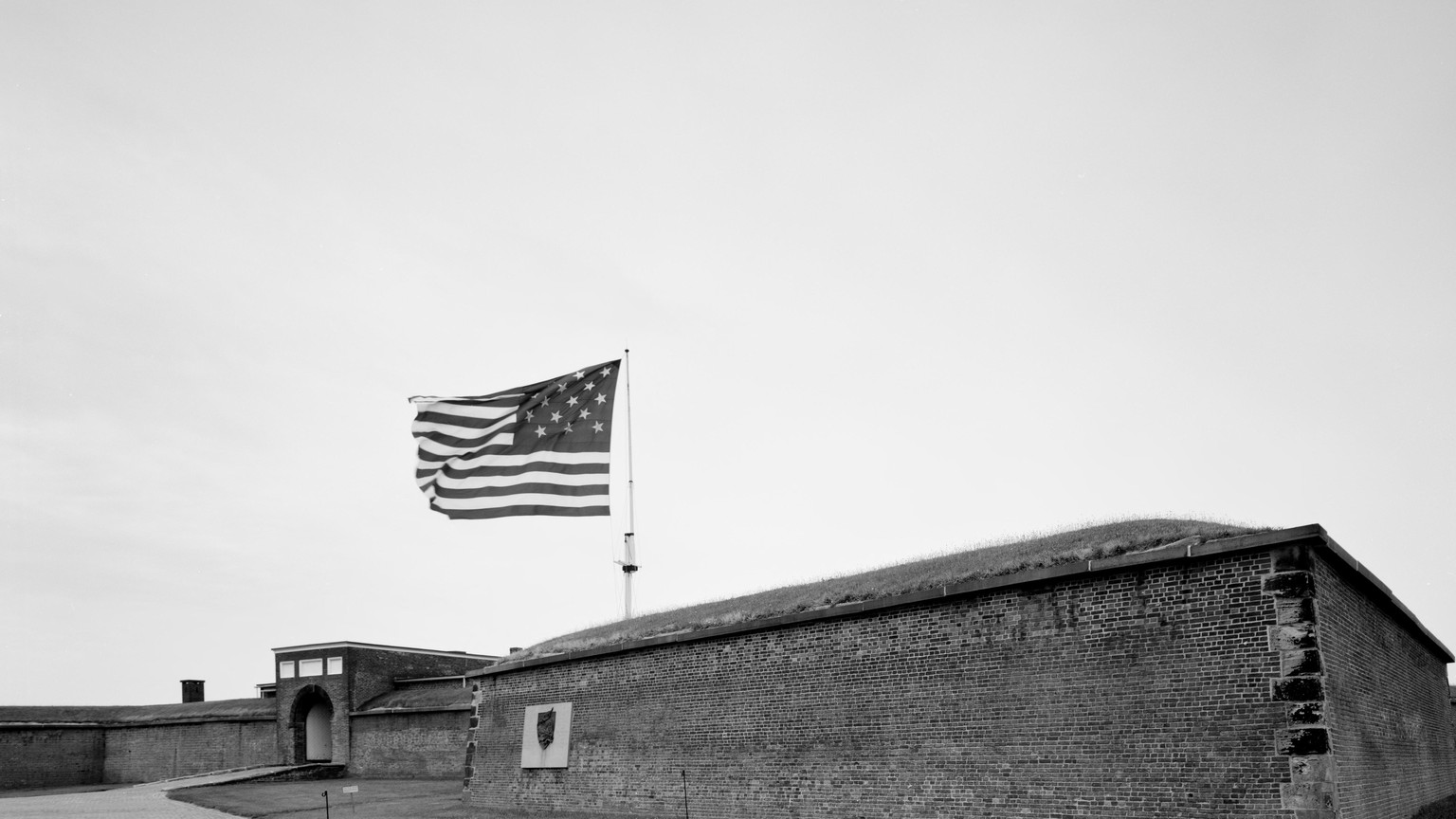 Historic Star-Spangled Banner-style flag flying over brick fort walls at Fort McHenry in Baltimore