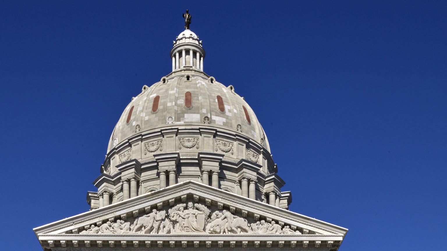Dome and sculpted pediment of the Missouri State Capitol in Jefferson City against a deep blue sky