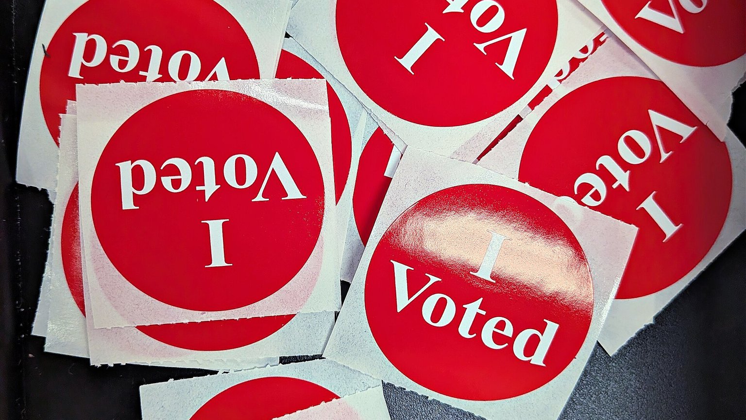 A pile of red &ldquo;I Voted&rdquo; stickers at a polling station