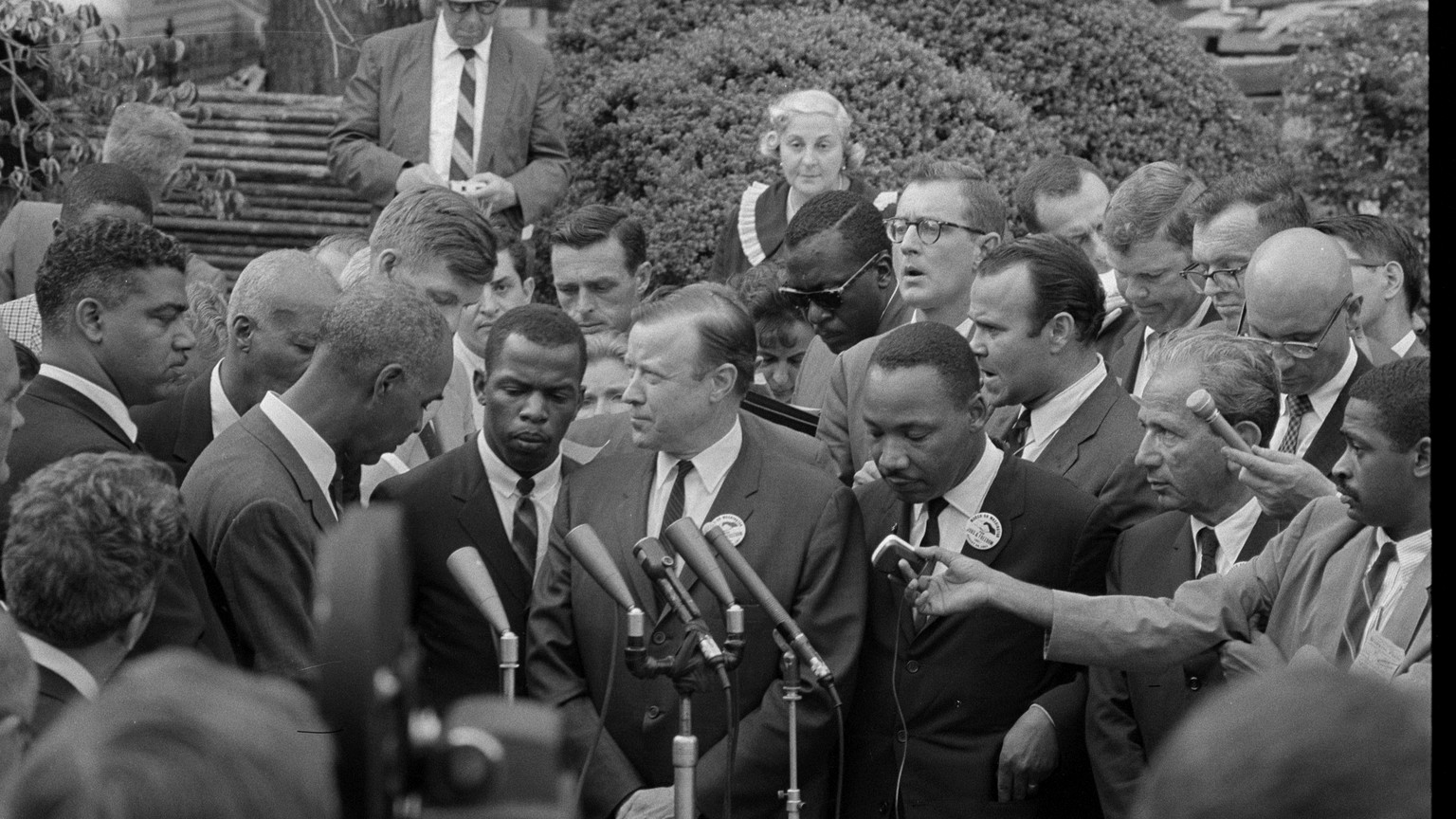 Martin Luther King, Jr. and other civil rights leaders speaking with reporters outdoors after the March on Washington